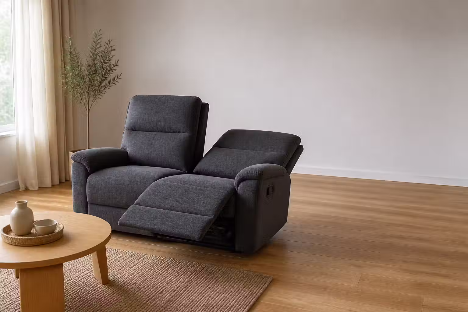 Mörkgrå reclinersoffa där ena sitsen är fälld bakåt med utfällt benstöd